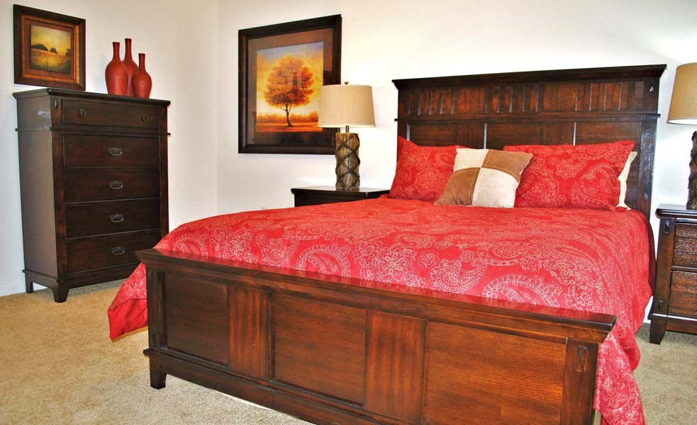 a bedroom with a bed with a red comforter