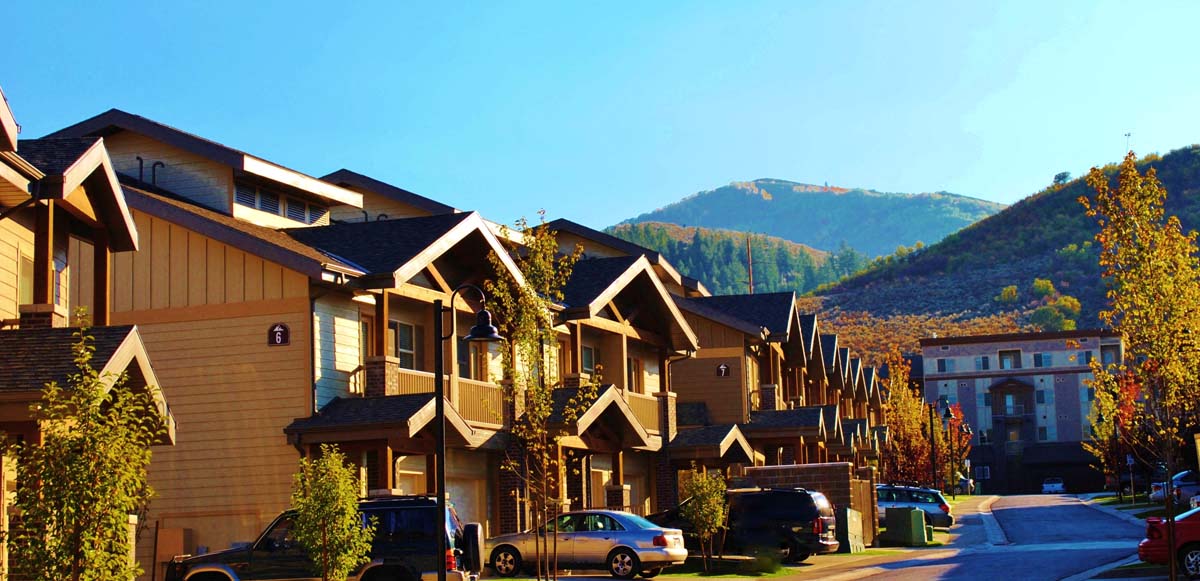 a row of houses with mountains in the background