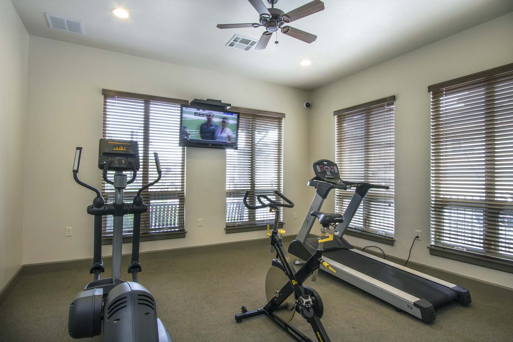 the gym is equipped with exercise equipment and a tv