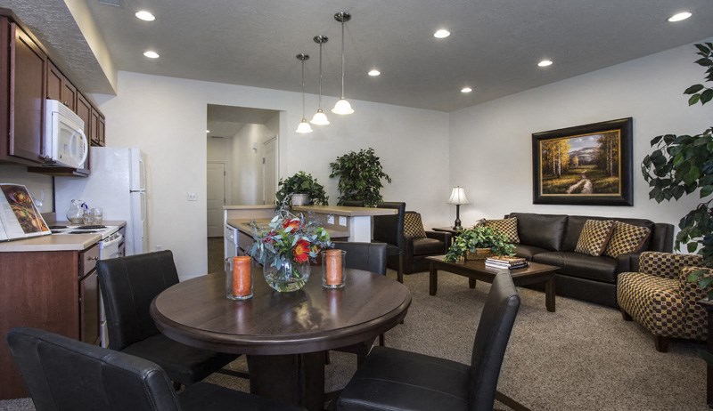 a living room and kitchen with a table and chairs