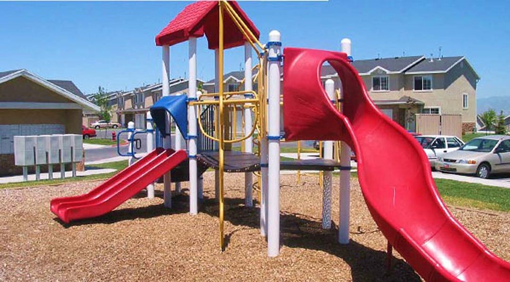a playground with a red slide and other playground equipment