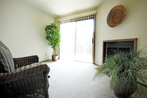 a living room with two wicker chairs and a fireplace