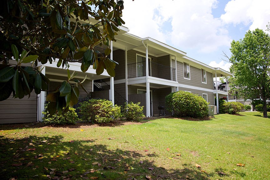 the front of the house has a lawn and a porch