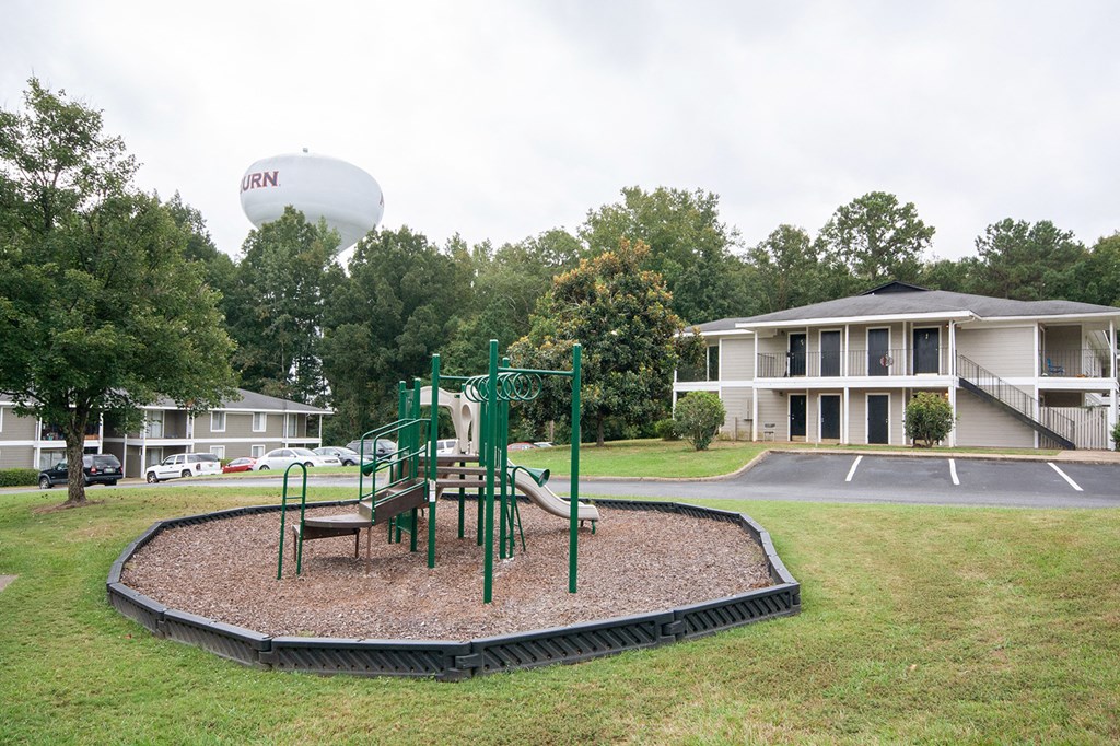 a playground in front of a building with a water balloon in the background