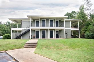 a white house with a lawn and a staircase