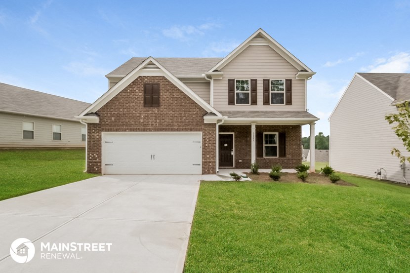 a home with a white garage door in front of a green lawn