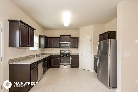 a kitchen with black cabinets and stainless steel appliances