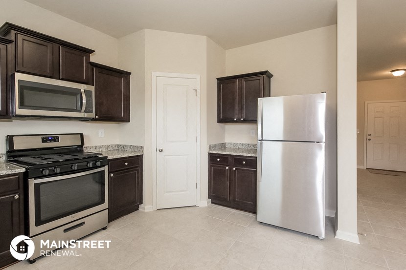 a kitchen with black cabinets and stainless steel appliances