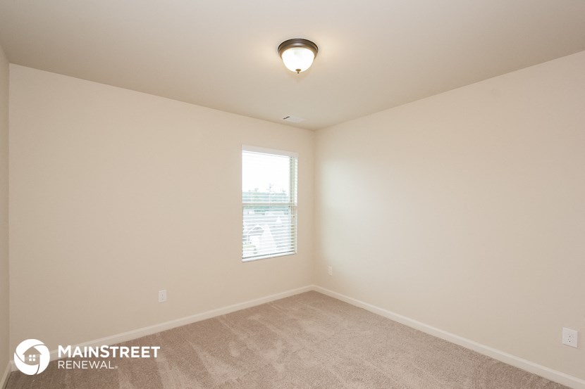 the spacious living room of a house with a window