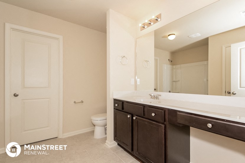 a bathroom with a toilet and a sink and a mirror
