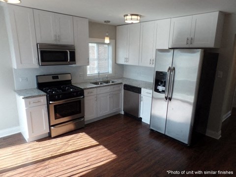A kitchen with white cabinets and stainless steel appliances.