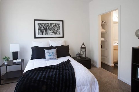 A bedroom with a large bed and a painting on the wall.