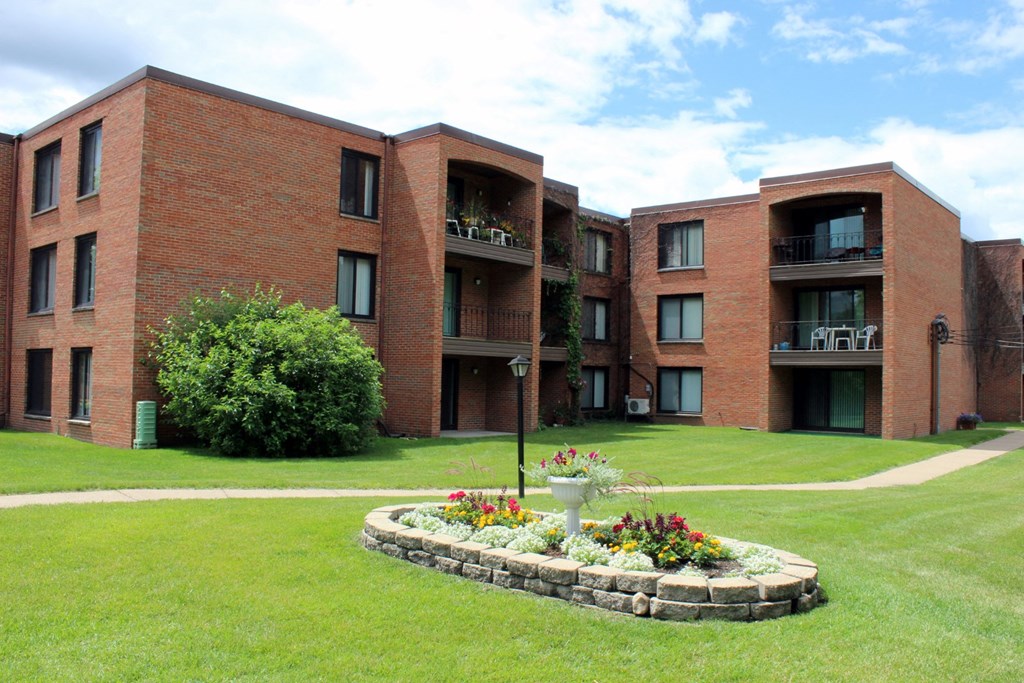 a large brick building with a flower garden in the middle