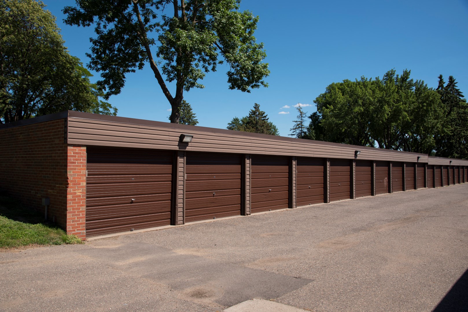 a row of garages with a parking lot and trees
