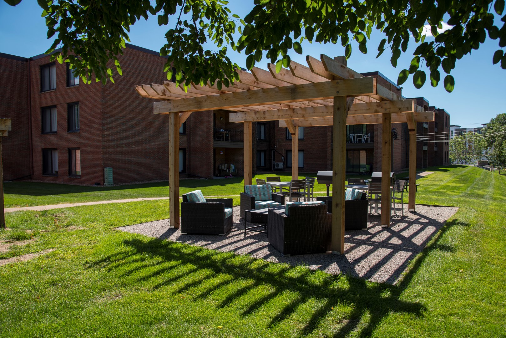 a patio with furniture and a wooden pergola