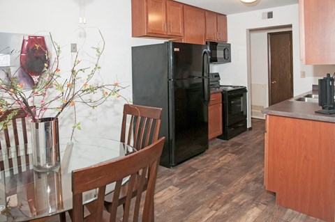 a kitchen with black appliances and a table and chairs