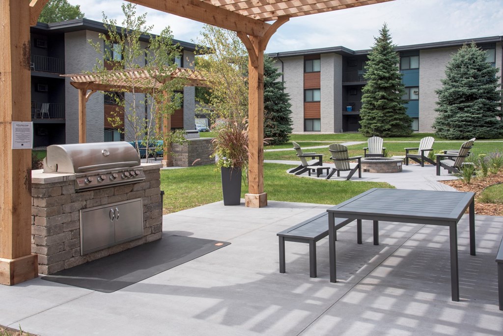 a patio with a barbecue grill and a picnic table