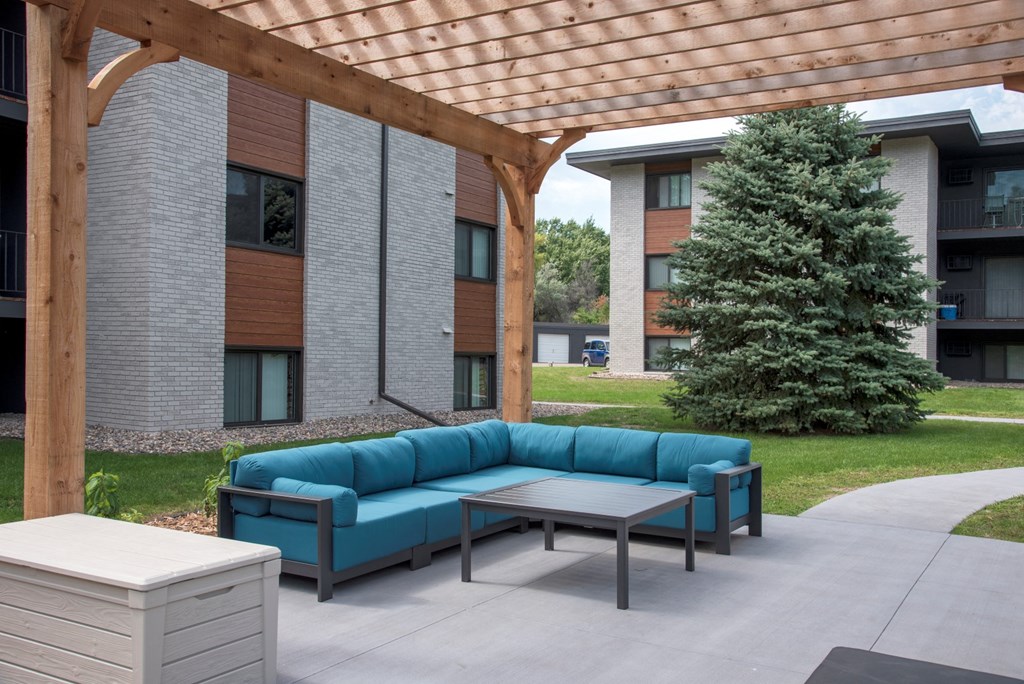 a covered patio with a blue couch and a coffee table