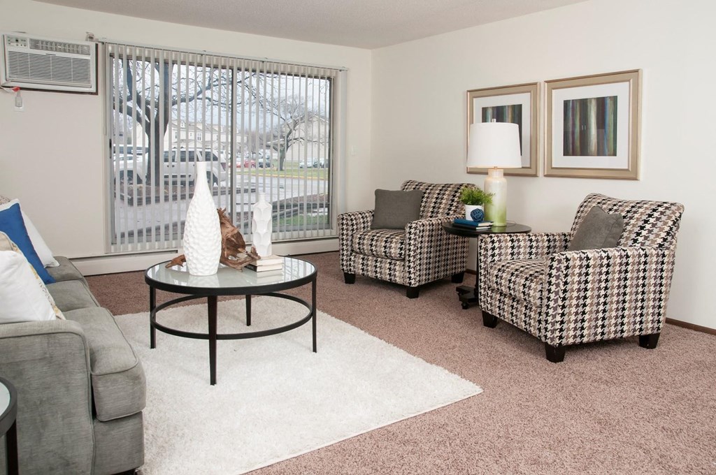 a living room with couches and chairs and a window