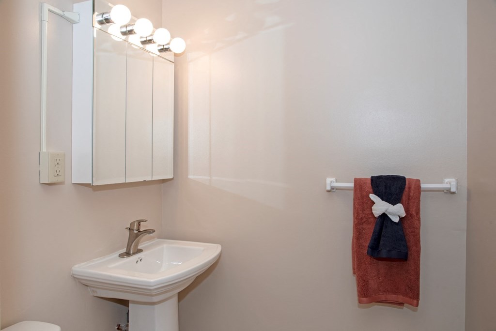 a bathroom with a sink and a mirror and a towel