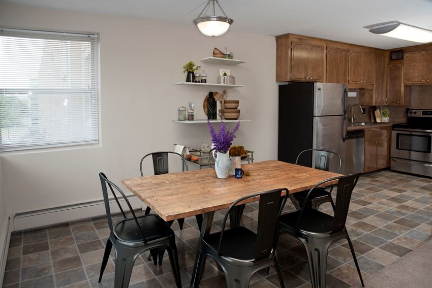 a dining area with a wooden table and black chairs