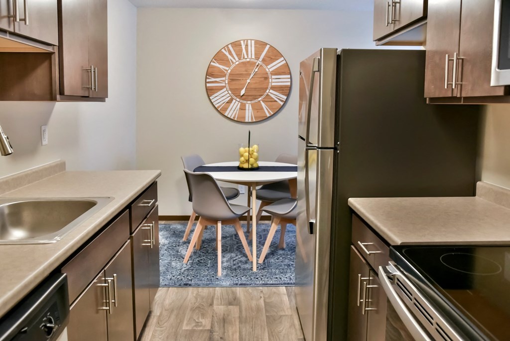 our apartments have a kitchen and dining room with a clock on the wall