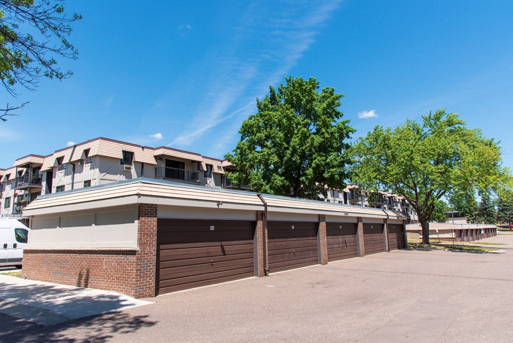 an empty parking lot in front of a building with a garage door