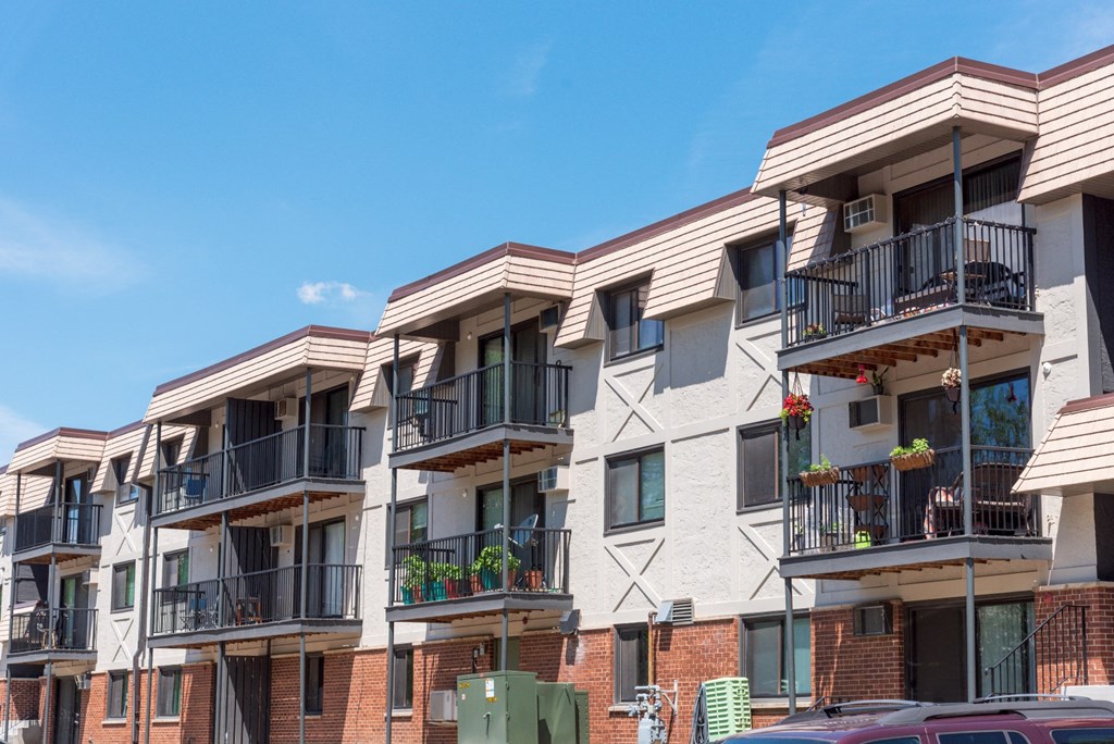 a row of apartments with balconies and a blue sky