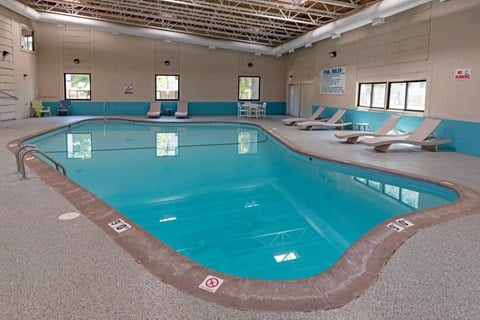 a large indoor swimming pool in a building with chairs