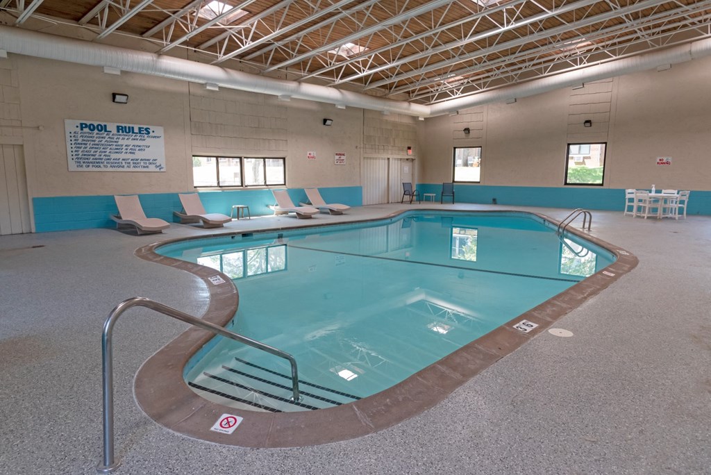 a large indoor swimming pool in a building with chairs