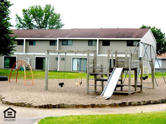 a playground with a house in the background