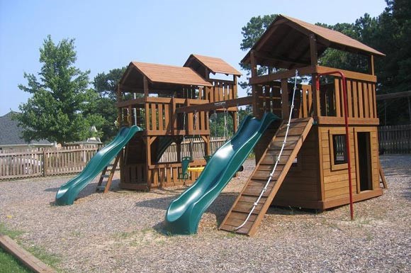 a playground with three slides and a swing set