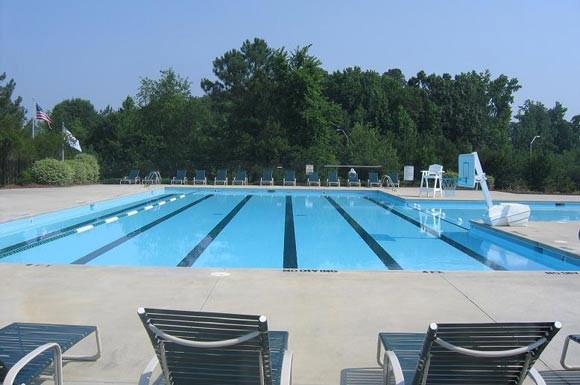 a large swimming pool with chairs around it