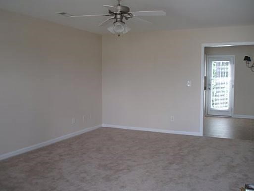 an empty living room with a ceiling fan