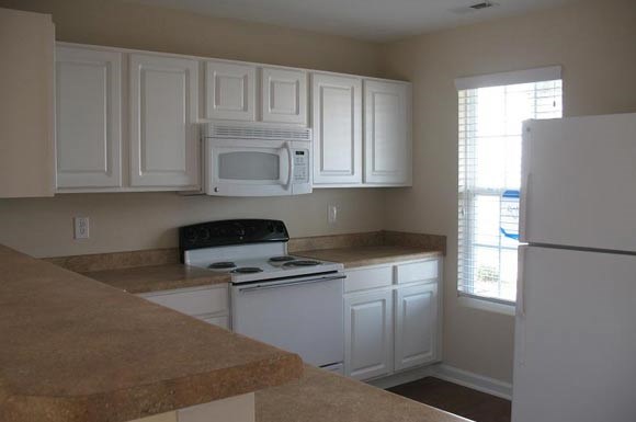 a kitchen with white appliances and white cabinets