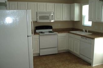 a kitchen with a white refrigerator freezer and a white stove top oven