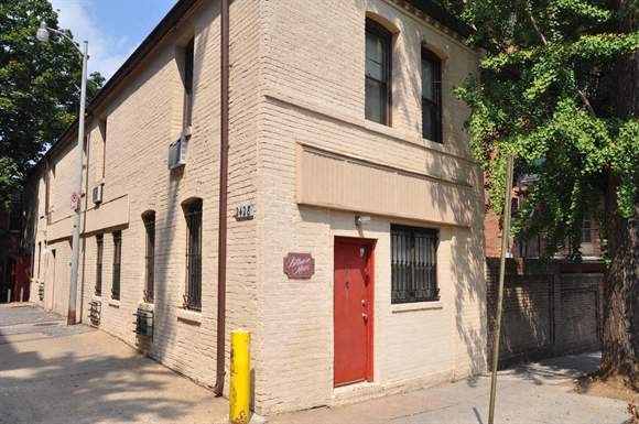 a white brick building with a red door