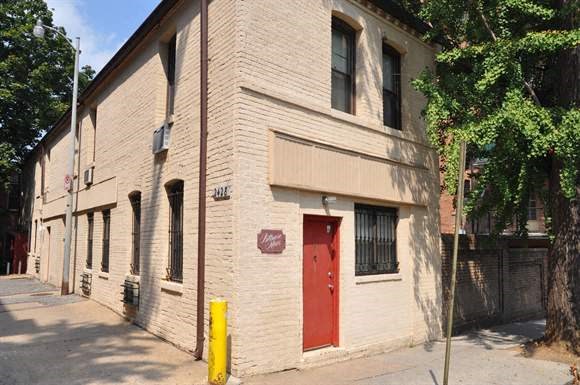 a white brick building with a red door