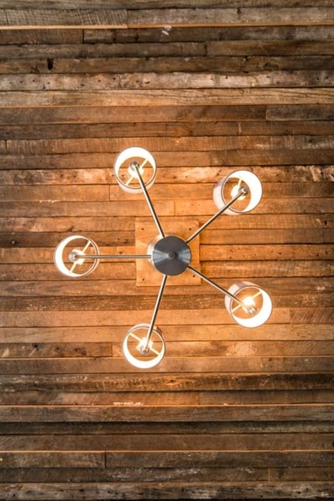 a clock hanging on a wooden wall