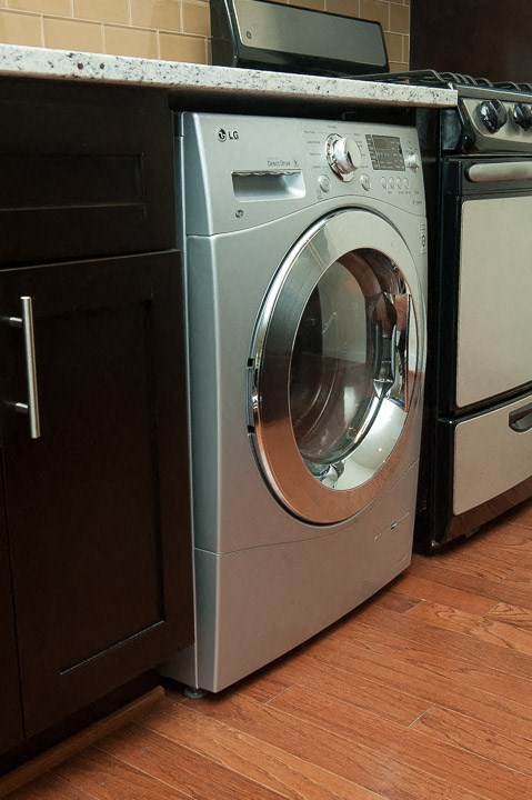 a front loading washer and dryer sit next to each other in a kitchen