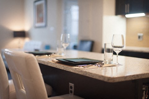a table with a tablet and wine glasses on it