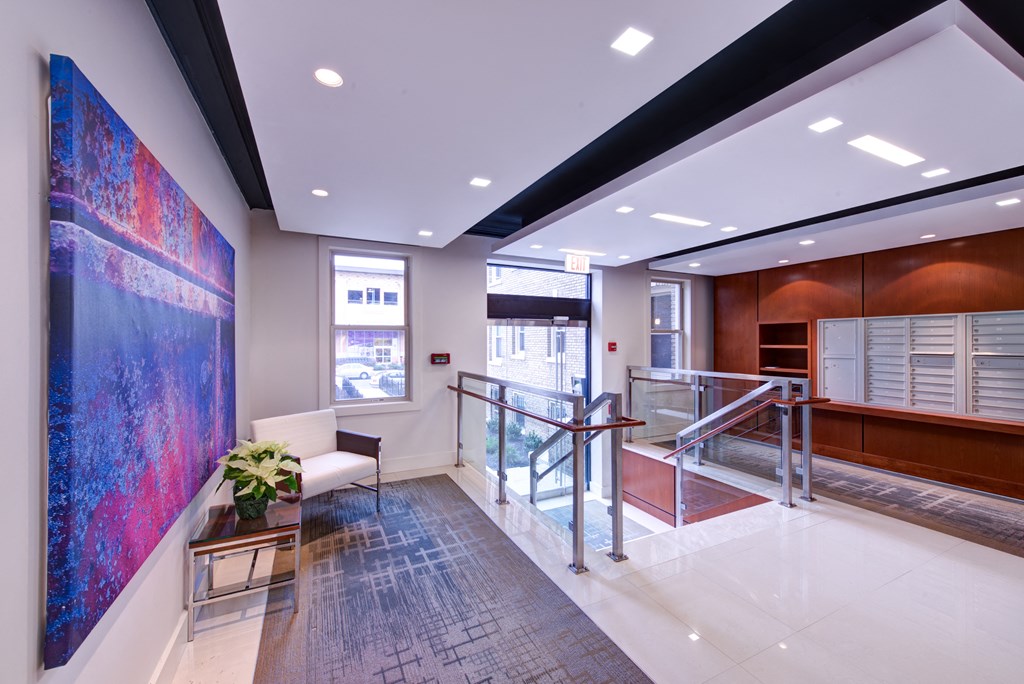 a lobby with a large painting on the wall and a staircase