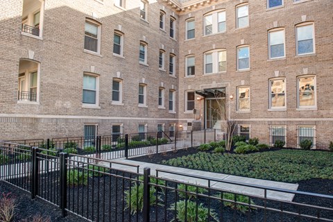 a large brick building with a garden in front of it