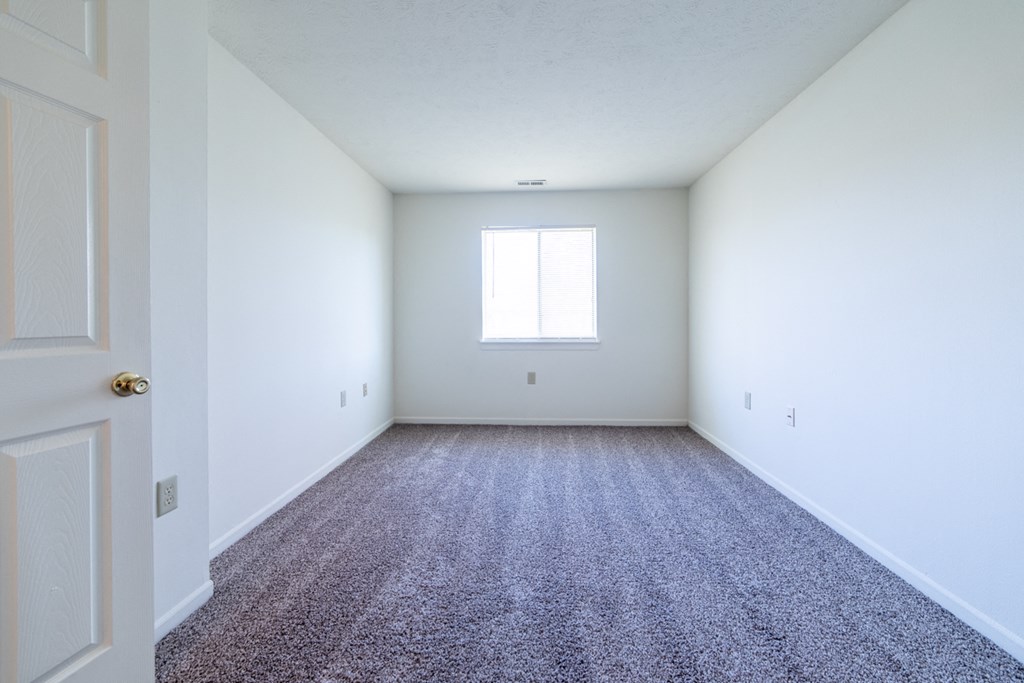 Bedroom with window and carpet at Bradford Run in Kokomo, IN