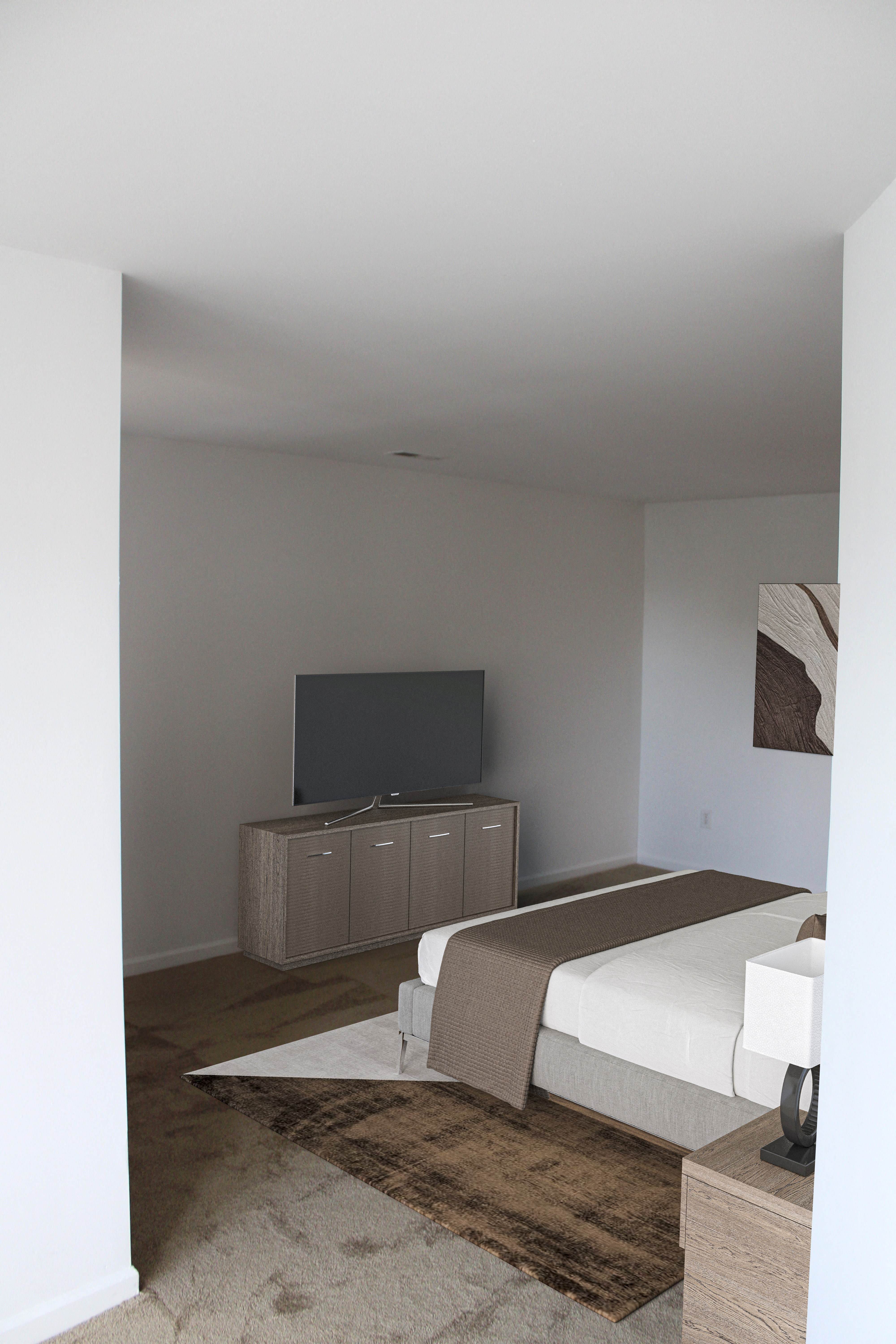 a view of a bedroom with a bed and a television