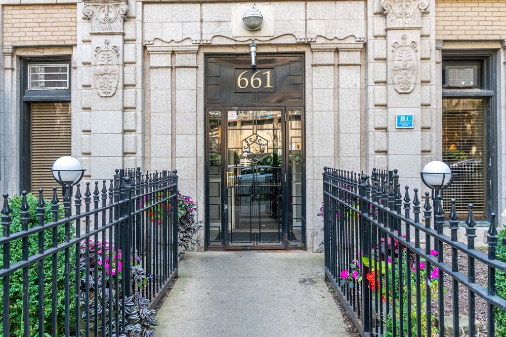 the front door of an apartment building with a wrought iron gate