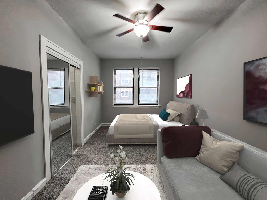 a living room with a bed and a ceiling fan