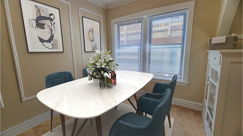 a dining room with a marble table and blue chairs