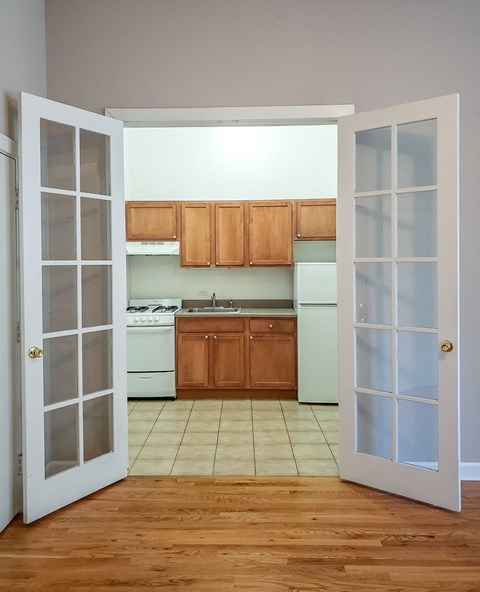 an empty kitchen with white appliances and wooden cabinets