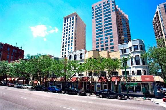 a city street with cars parked in front of tall buildings